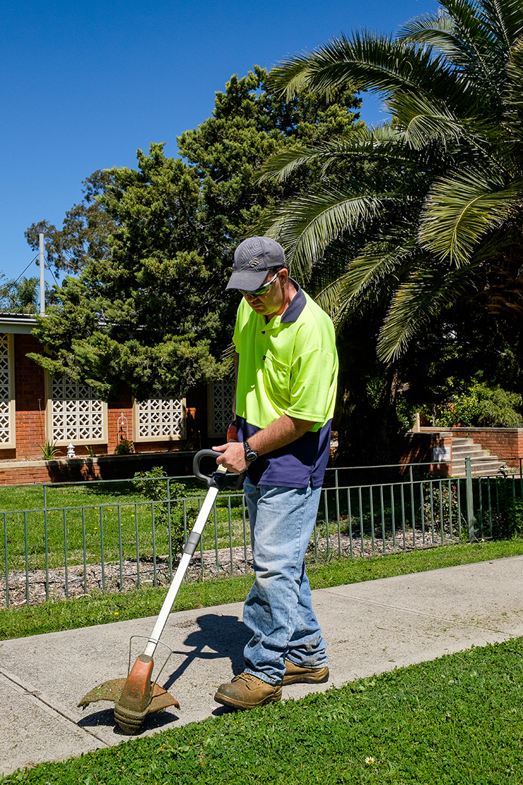 Image of a Spare Hands Work Crew staff member with a line trimmer