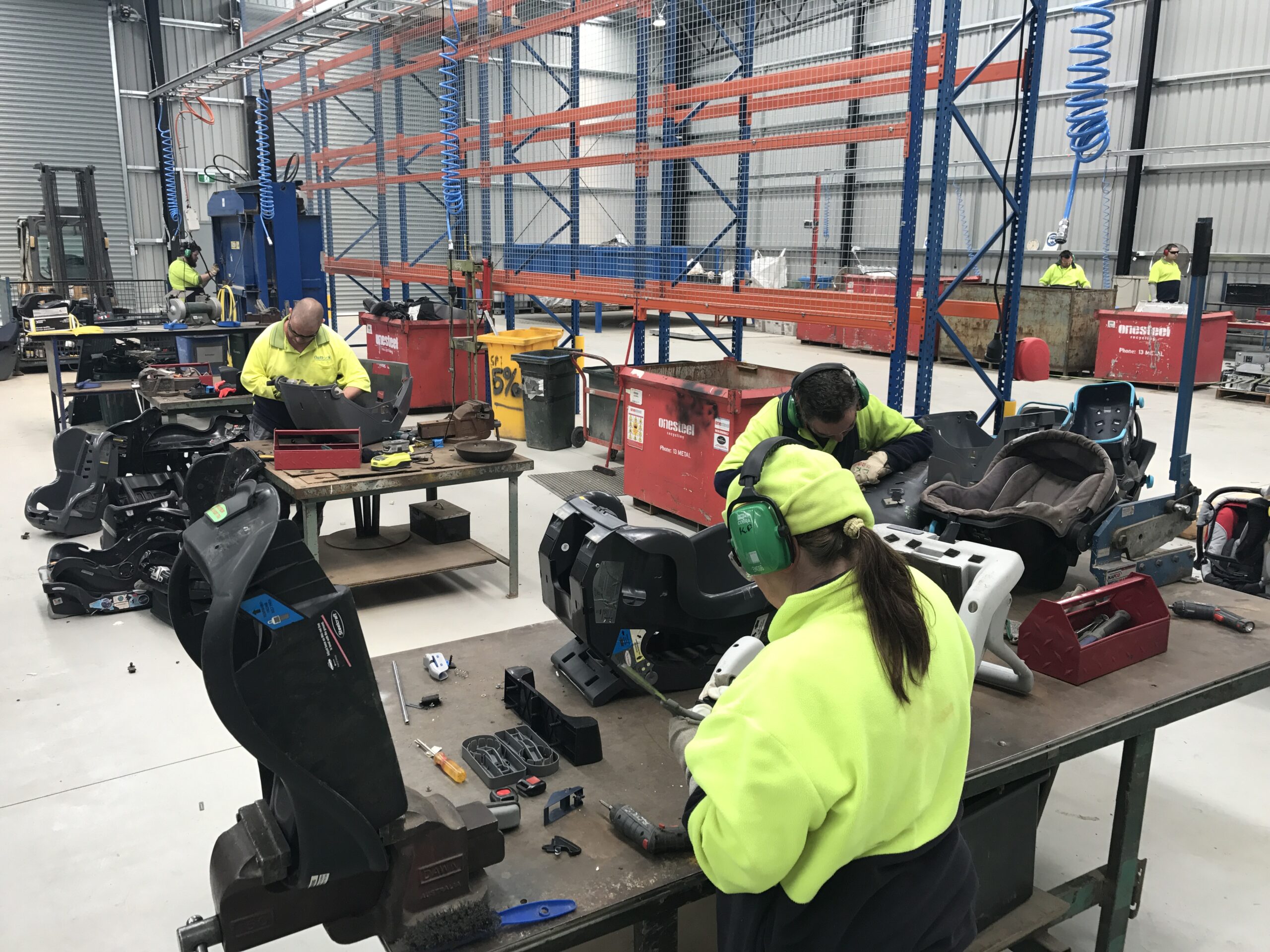 work team dismantling child safety seats for recycling
