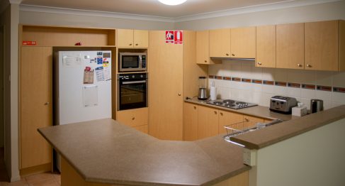 A spacious kitchen with lots of counter and storage space. Cabinets doors are a light timber with modern kitchen appliances throughout